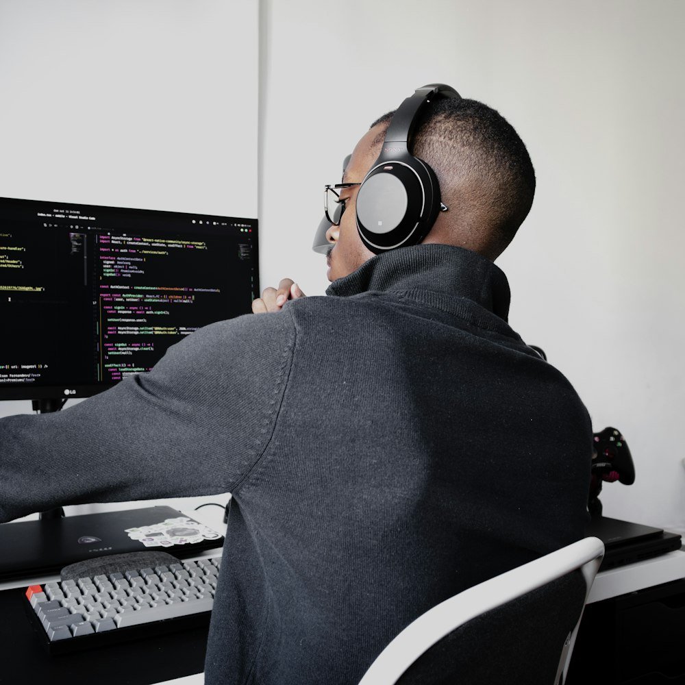 Técnico con audífonos trabajando frente a varios monitores